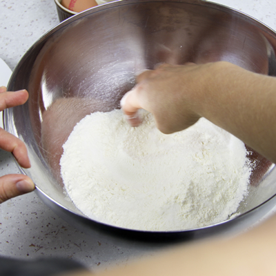 Dans un saladier, mélanger la farine avec la pincée de sel (et le sucre pour une